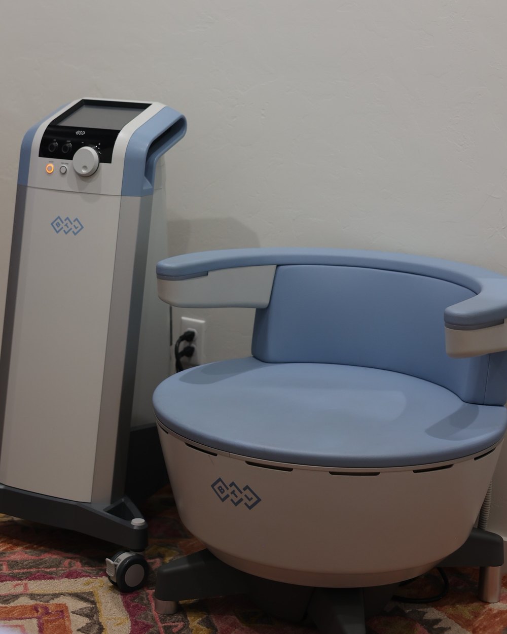 The BTL Emsella chair and its control tower in a Gudgel Aesthetics treatment room