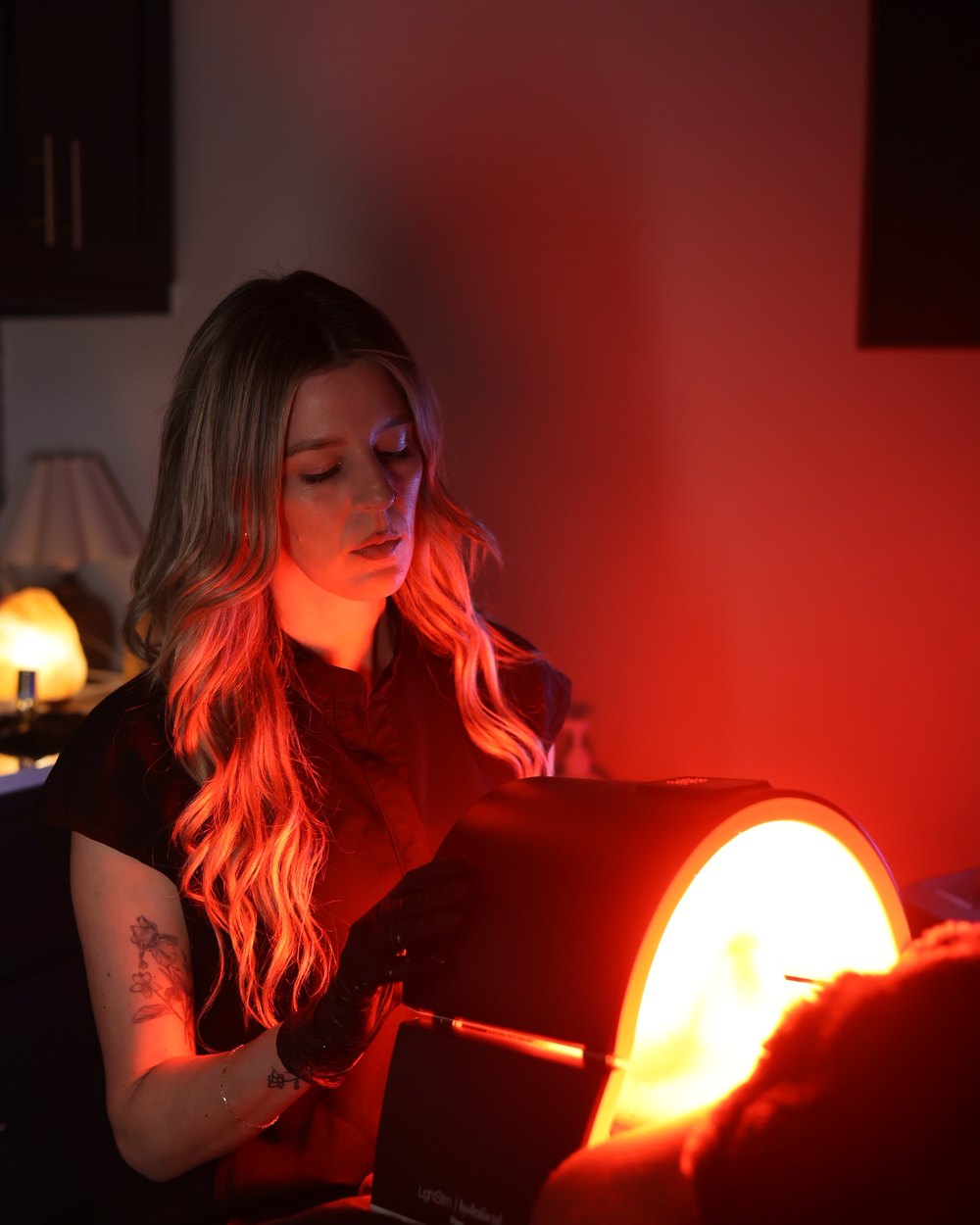 Red light therapy panel positioned over a client during a facial at Gudgel Aesthetics